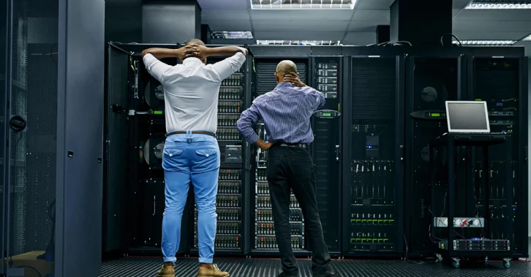 IT technicians building data center redundancy in server room