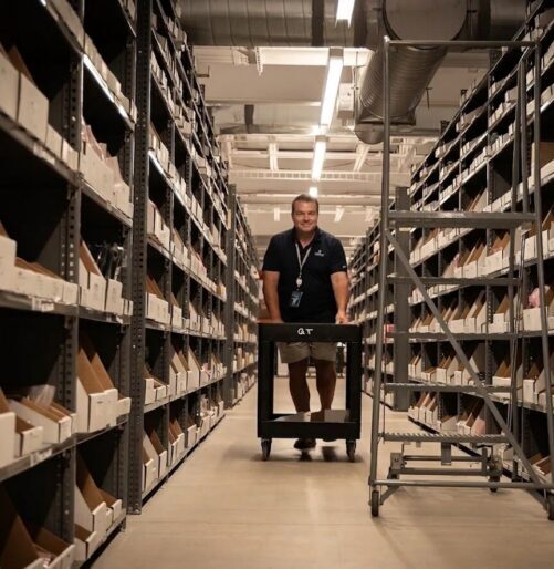 technicus die onderdelen uit het magazijn haalt voor het onderhoud van de server