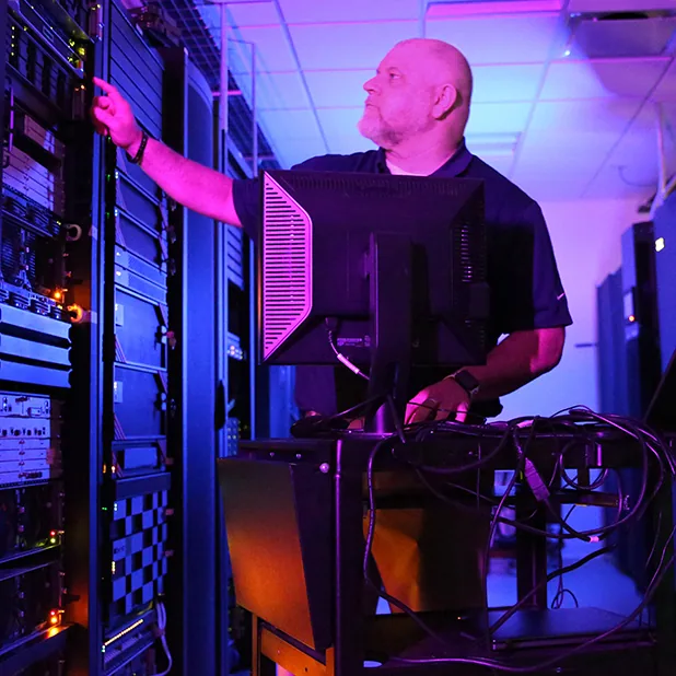 Technicus die vanuit een monitorwagen een serverrek controleert tijdens IBM Power-cloudmigratiediensten